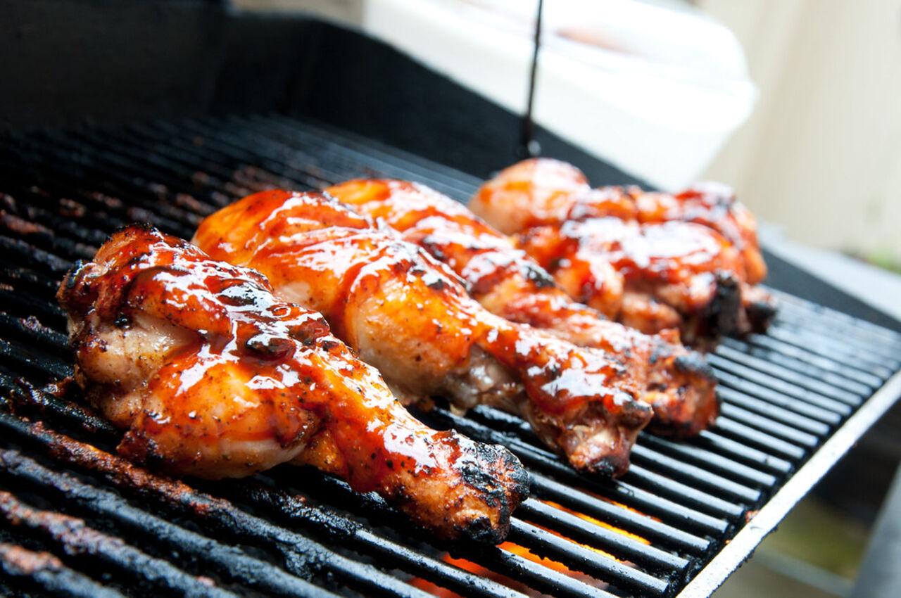 Hähnchen-Drumsticks werden auf dem Grill mit Sauce glasiert