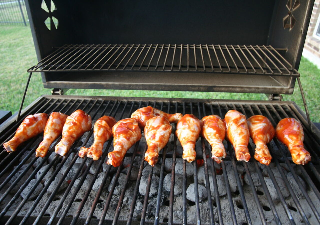Frisch glasierte Hähnchen-Drumsticks nebeneinander auf dem Grillrost